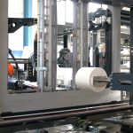 Die von Koch Robotersysteme integrierte Verpackungslinie führt Rollen per robotergesteuertem Spanndorngreifer durch die RoRo StretchPack-Verpackungsmaschine von Tentoma (Quelle: Tentoma)